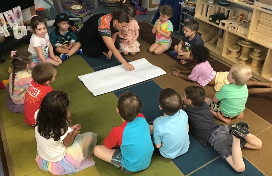 Kylie sitting in a circle with students taking them through a creative learning activity